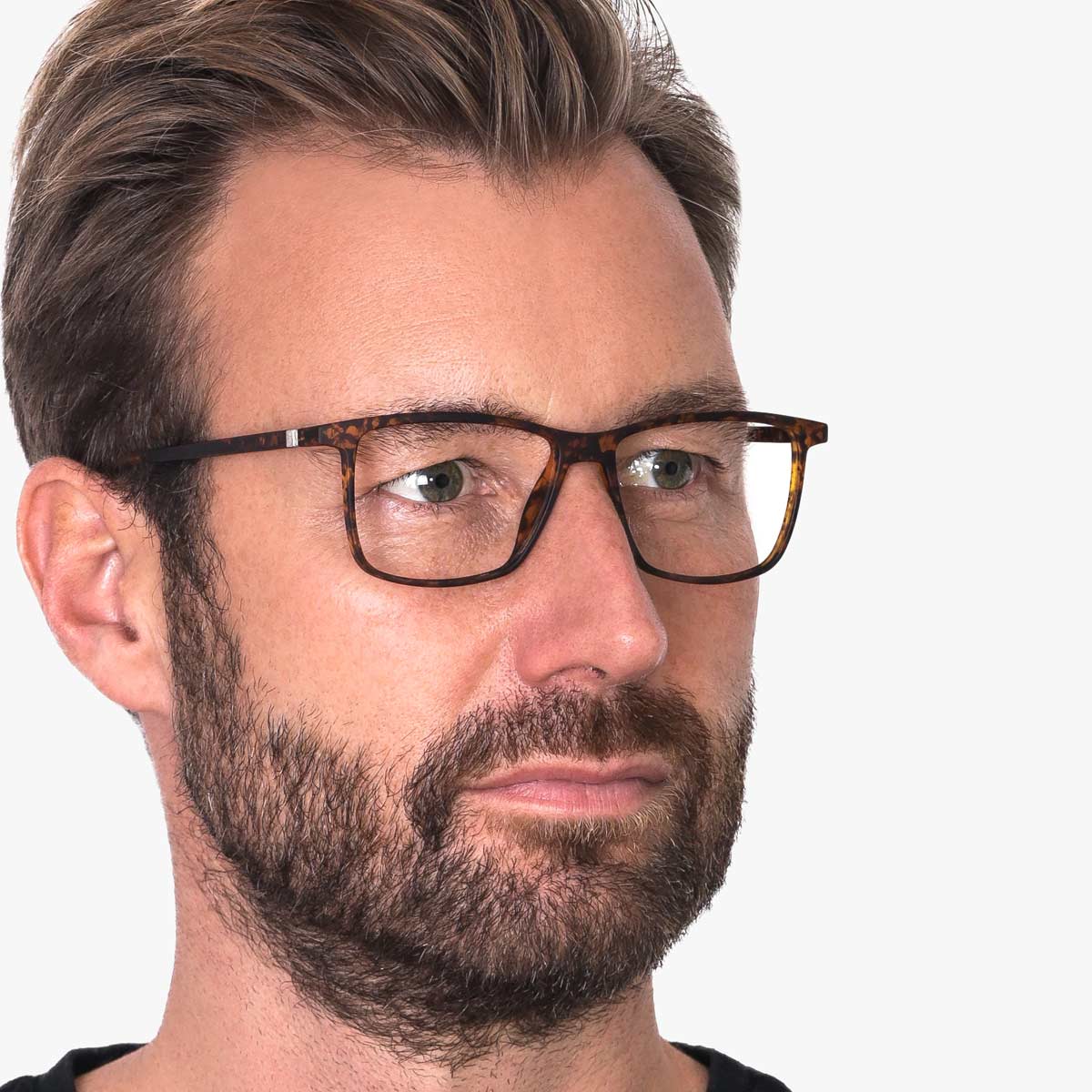 Person wearing tortoiseshell square reading glasses